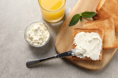 Photo of Delicious toasted bread slices served on grey textured table, flat lay