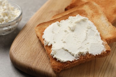 Photo of Delicious toasted bread slices with cream cheese on grey table, closeup