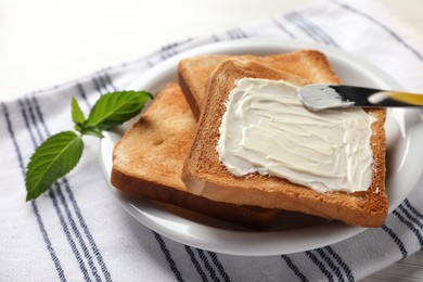 Photo of Delicious toasted bread slices with butter, mint and knife on white table