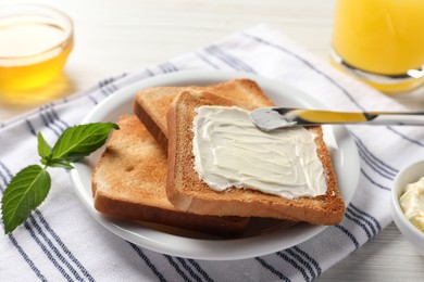 Photo of Delicious toasted bread slices with butter served on white table