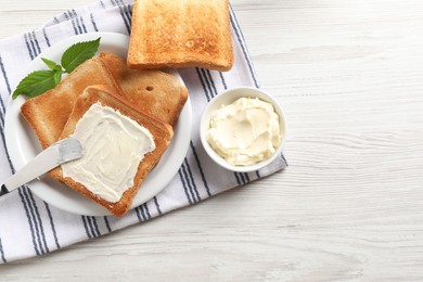 Photo of Delicious toasted bread slices with butter and mint on white wooden table, flat lay. Space for text