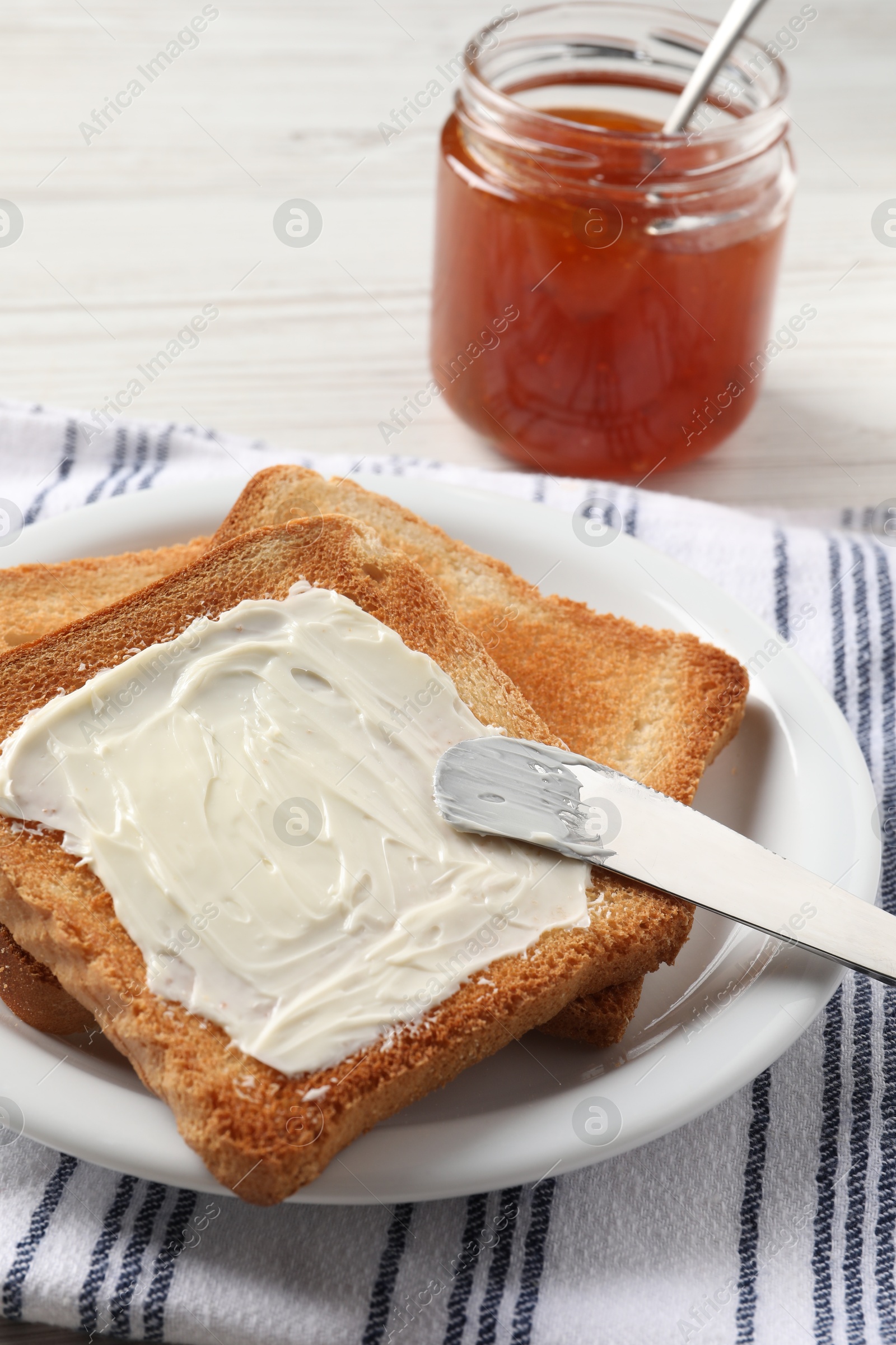 Photo of Delicious toasted bread slices with butter served on white table