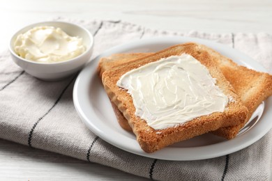 Delicious toasted bread slices with butter on white table, closeup