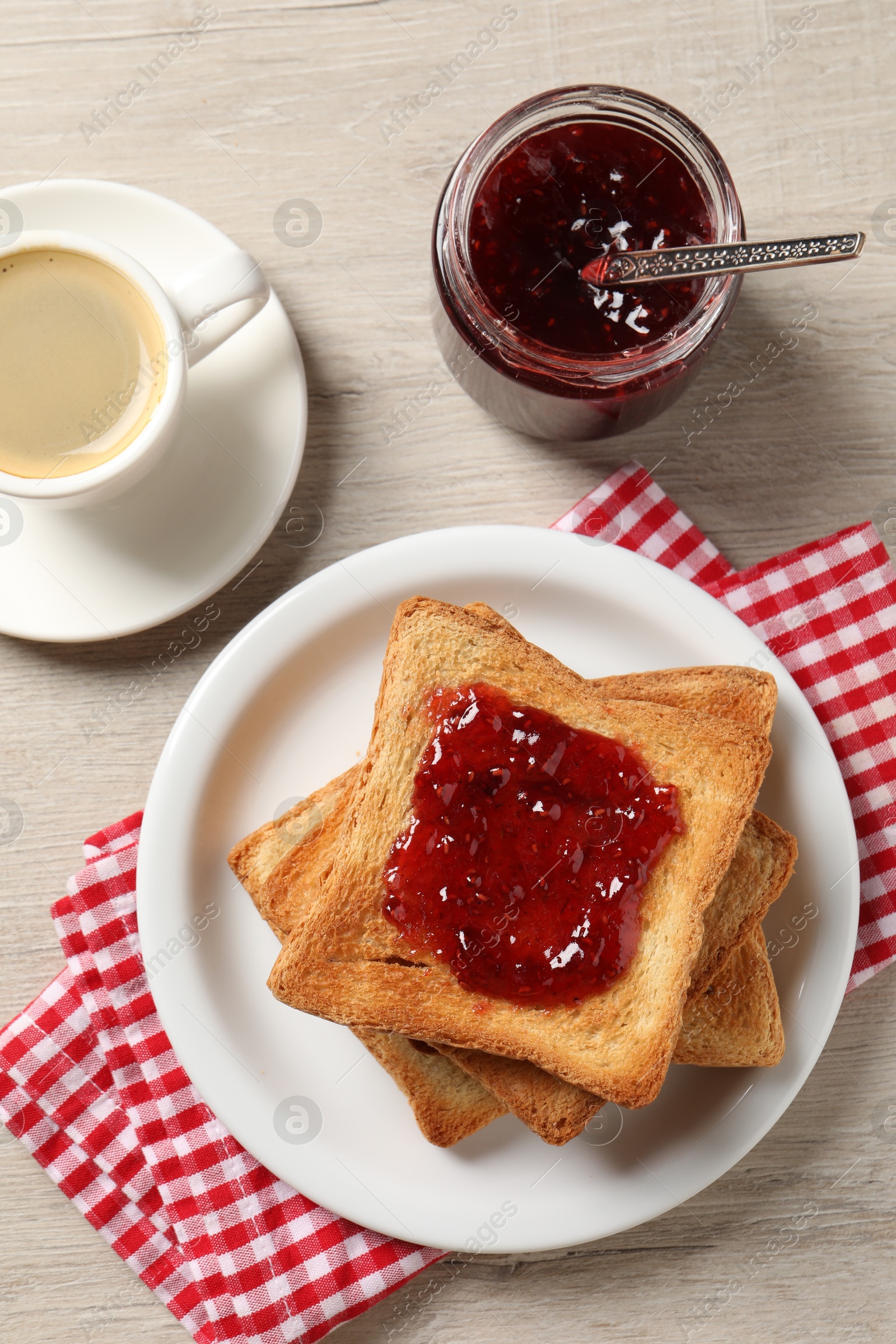 Photo of Delicious toasted bread slices served on wooden table, flat lay