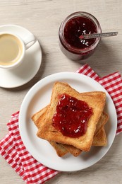 Photo of Delicious toasted bread slices served on wooden table, flat lay