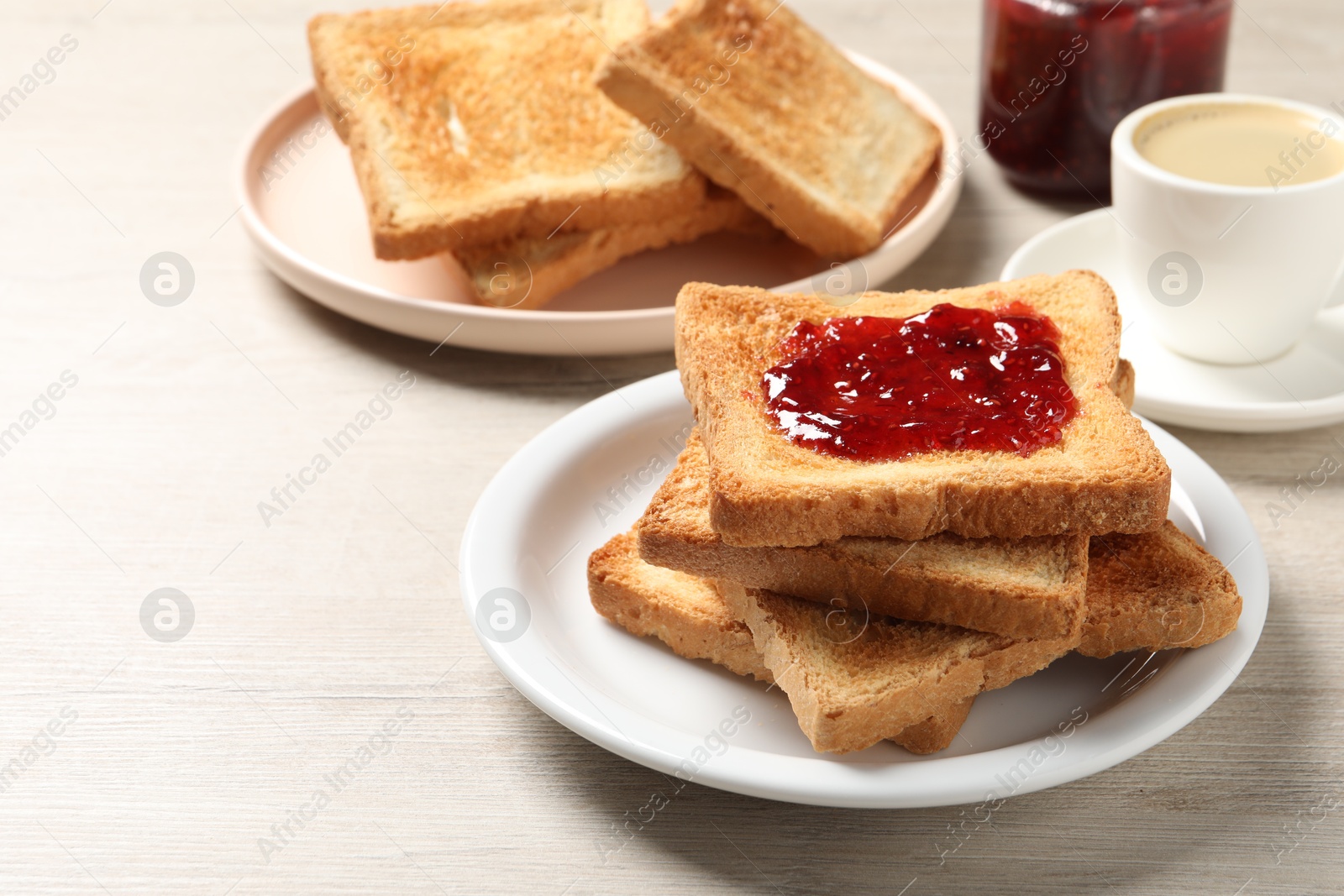 Photo of Delicious toasted bread slices with jam served on wooden table