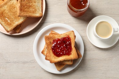 Photo of Delicious toasted bread slices served on wooden table, flat lay