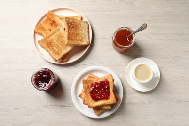 Photo of Delicious toasted bread slices served on wooden table, flat lay