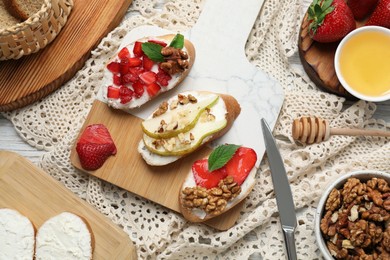 Board with different tasty ricotta bruschettas and ingredients on table, flat lay