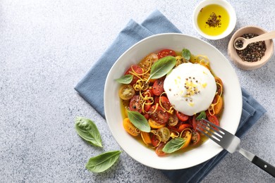 Photo of Delicious fresh burrata salad in bowl served on light gray textured table, flat lay. Space for text