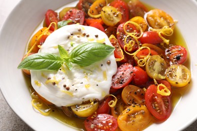 Photo of Delicious fresh burrata salad in bowl on table, top view