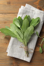 Photo of Bunch of green sage leaves on wooden table, top view