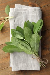 Photo of Bunch of green sage leaves on wooden table, top view