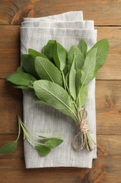 Photo of Bunch of green sage leaves on wooden table, top view