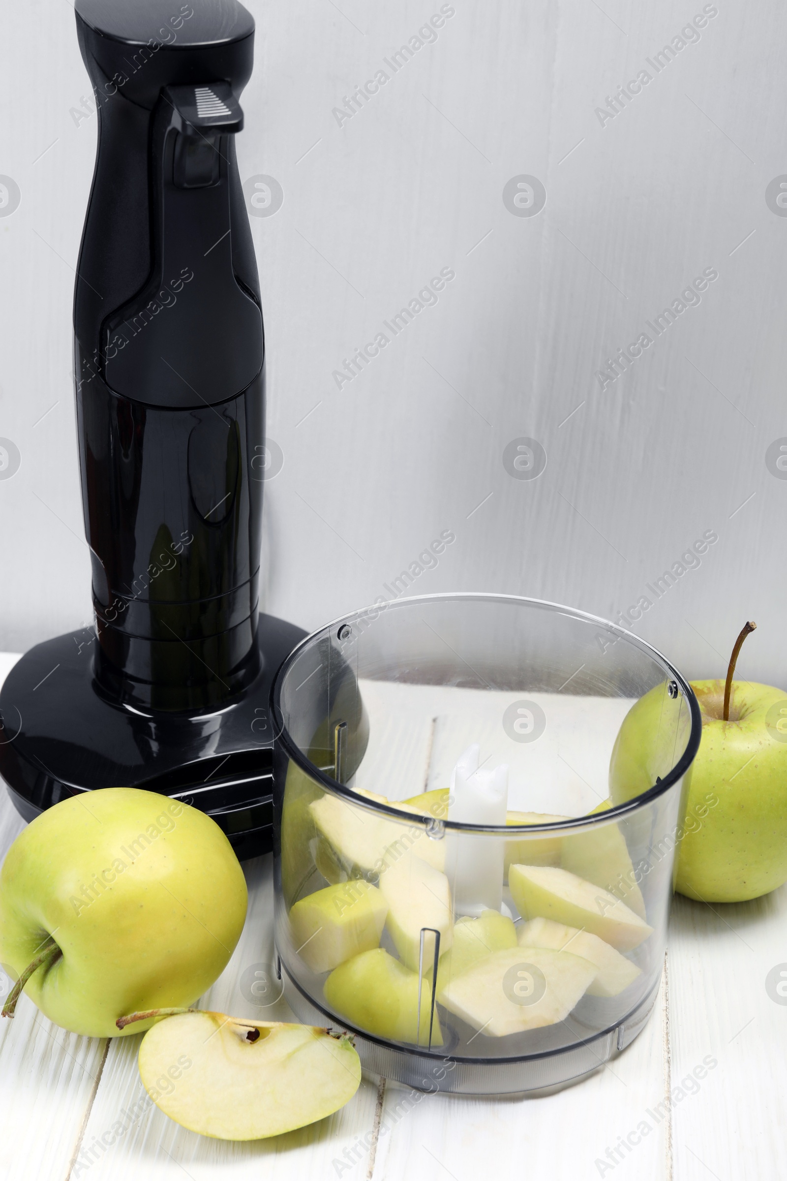 Photo of Hand blender kit and fresh apples on white wooden table