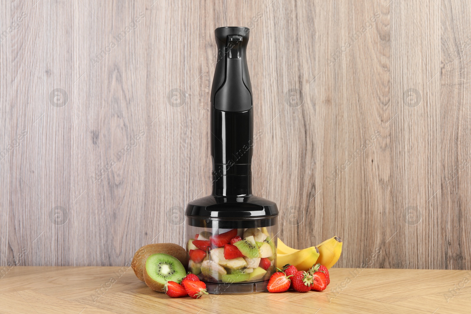 Photo of Hand blender kit, fresh fruits and strawberries on wooden table