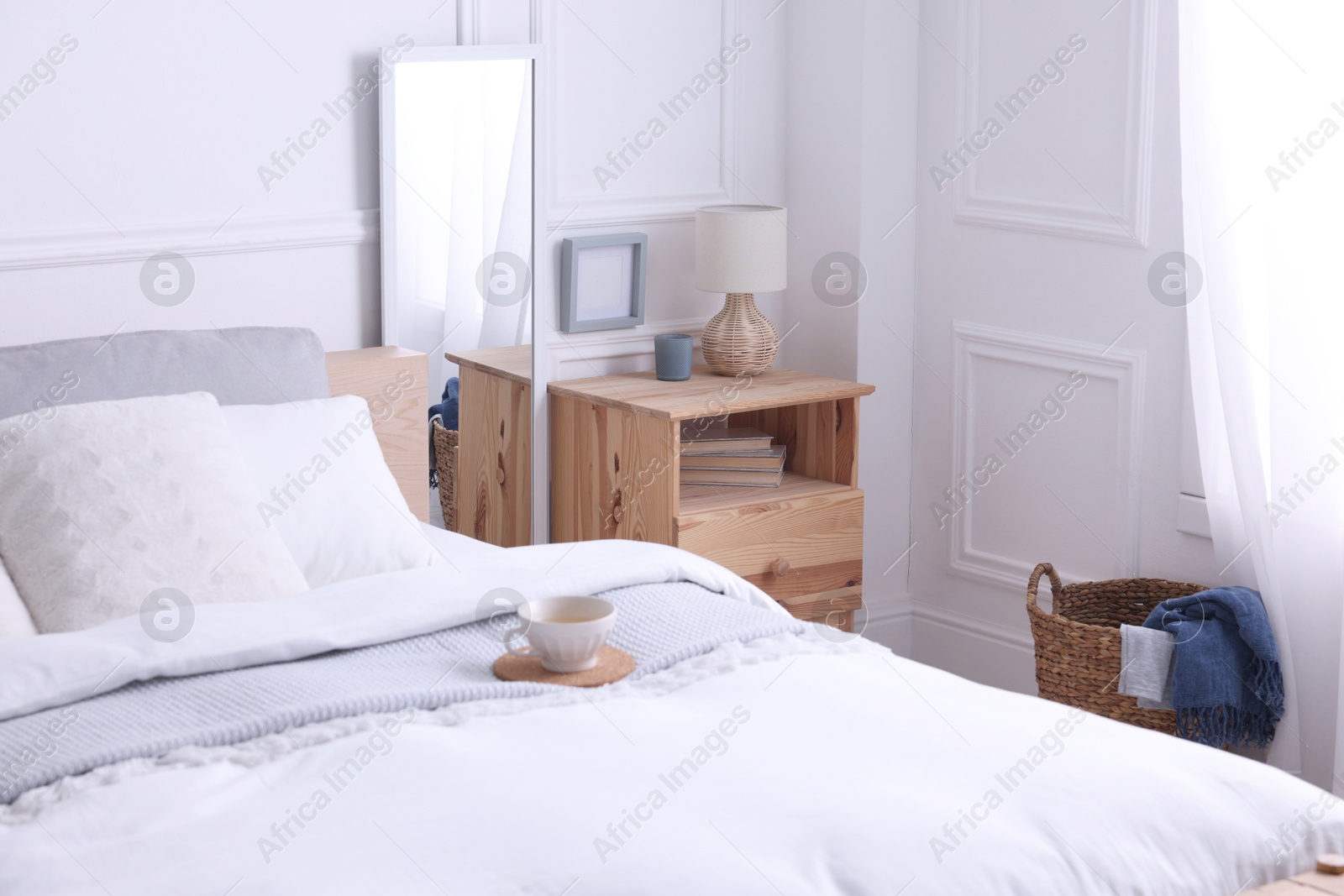 Photo of Stylish living room interior with bed, bedside table and lamp