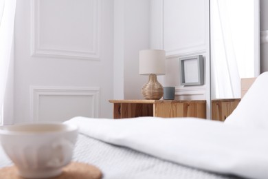 Photo of Stylish living room interior with bed, bedside table and lamp