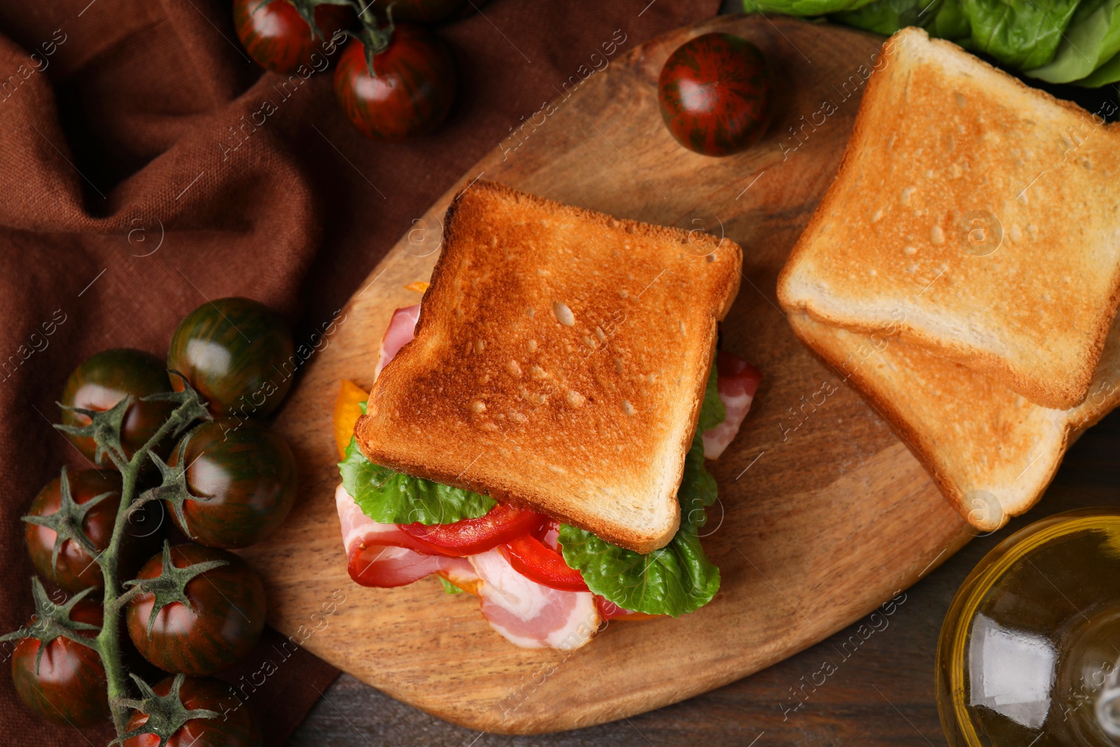 Photo of Tasty sandwiches with bacon and tomatoes on wooden table, flat lay