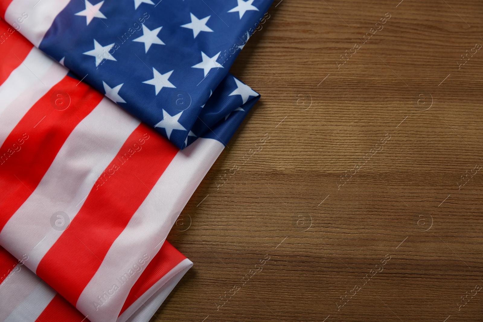 Photo of Flag of USA on wooden table, top view. Space for text