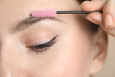 Photo of Young woman with spoolie brush, closeup. Eyebrow correction