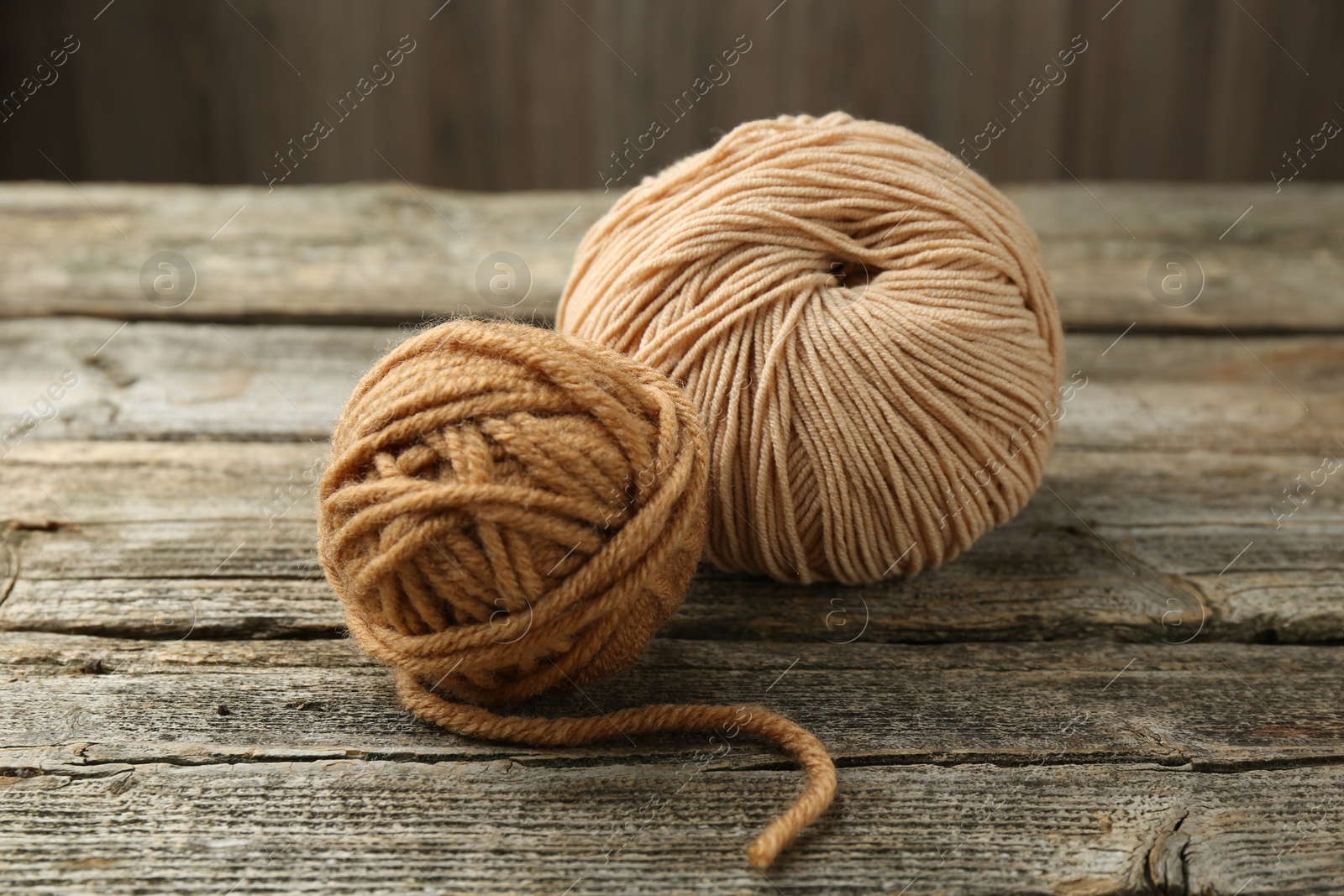 Photo of Skeins of soft yarn for knitting on wooden table