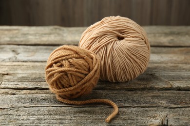 Photo of Skeins of soft yarn for knitting on wooden table