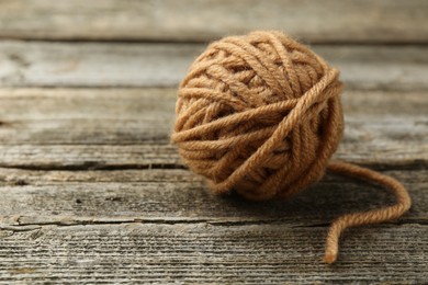 Photo of Skein of soft yarn for knitting on wooden table, closeup. Space for text