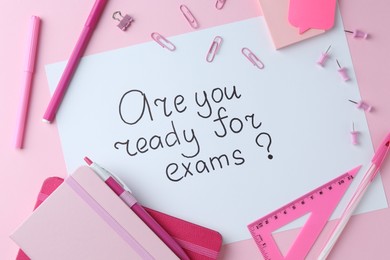 Photo of Paper note with question Are You Ready For Exams and stationery on pink background, flat lay