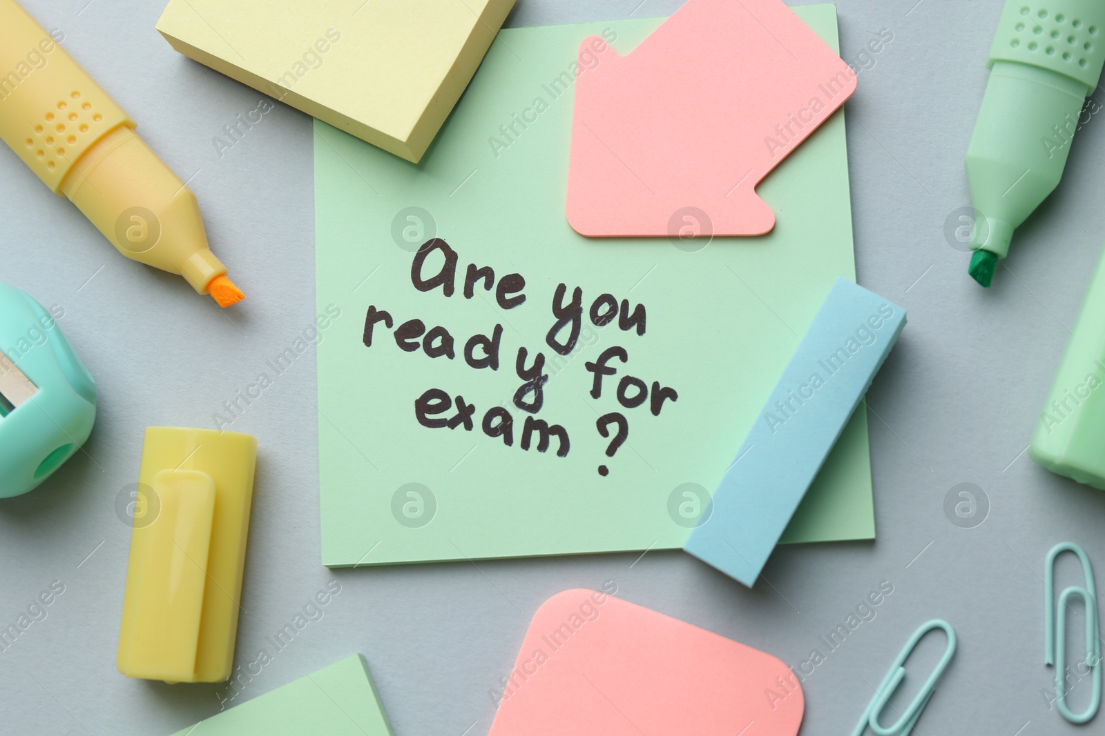 Photo of Paper note with question Are You Ready For Exam and stationery on grey background, flat lay