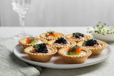 Photo of Delicious canapes with salmon and caviar on beige textured table, closeup