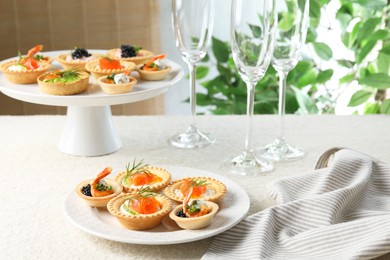 Delicious canapes with shrimps, salmon and caviar on beige textured table