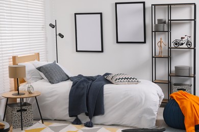 Teen's room interior with modern furniture and empty frames on wall