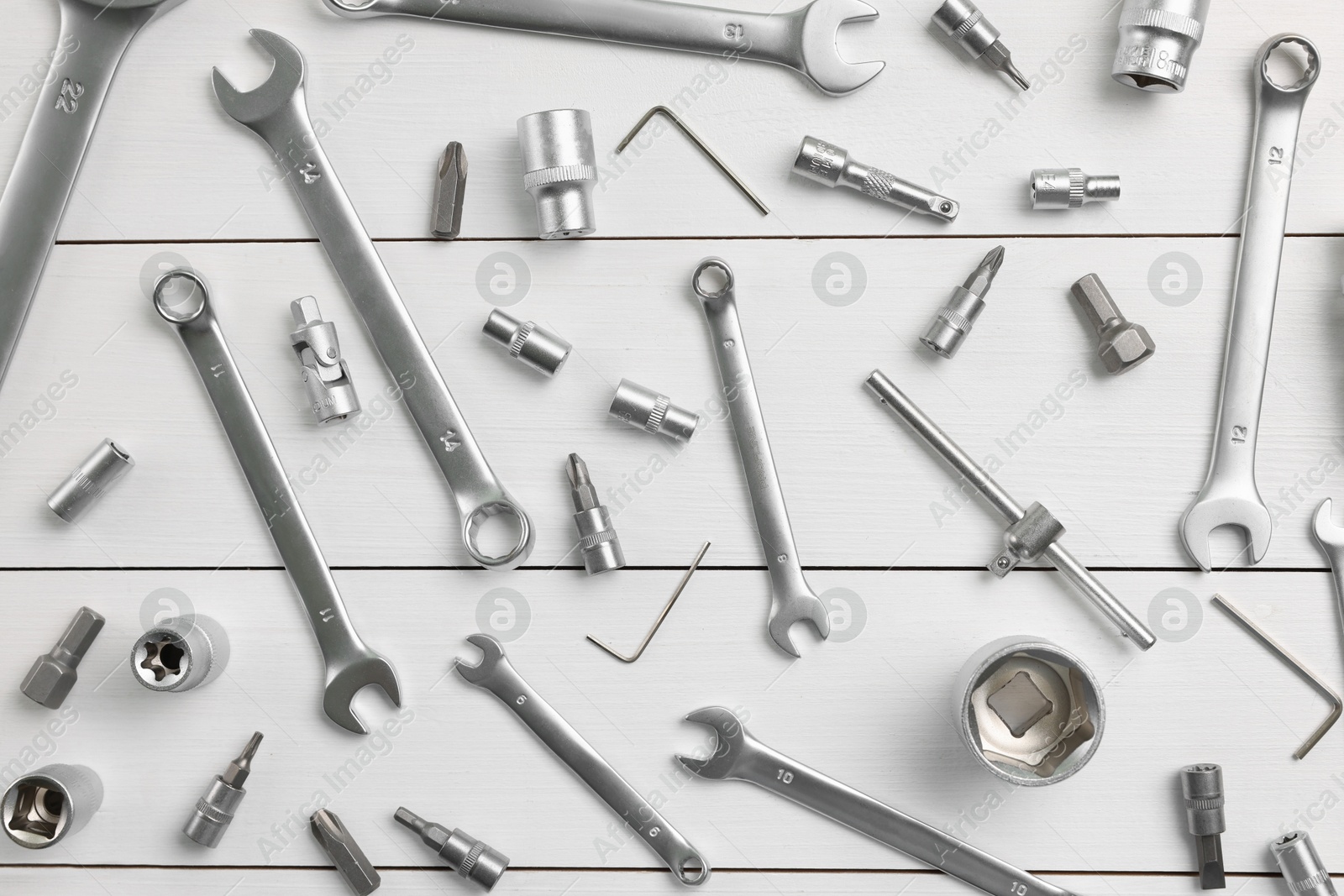 Photo of Auto mechanic's tools on white wooden table, flat lay