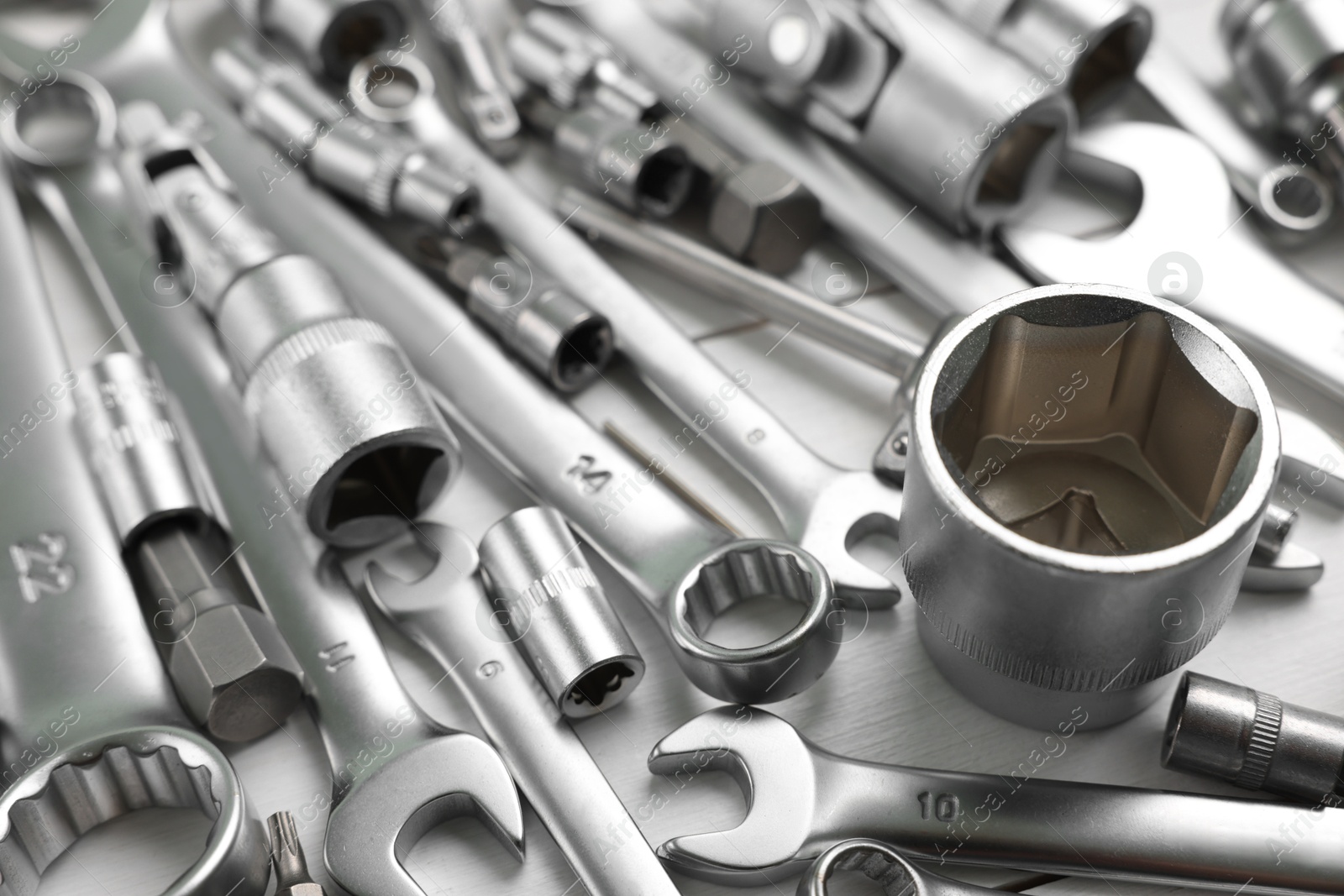 Photo of Auto mechanic's tools on white wooden table, closeup