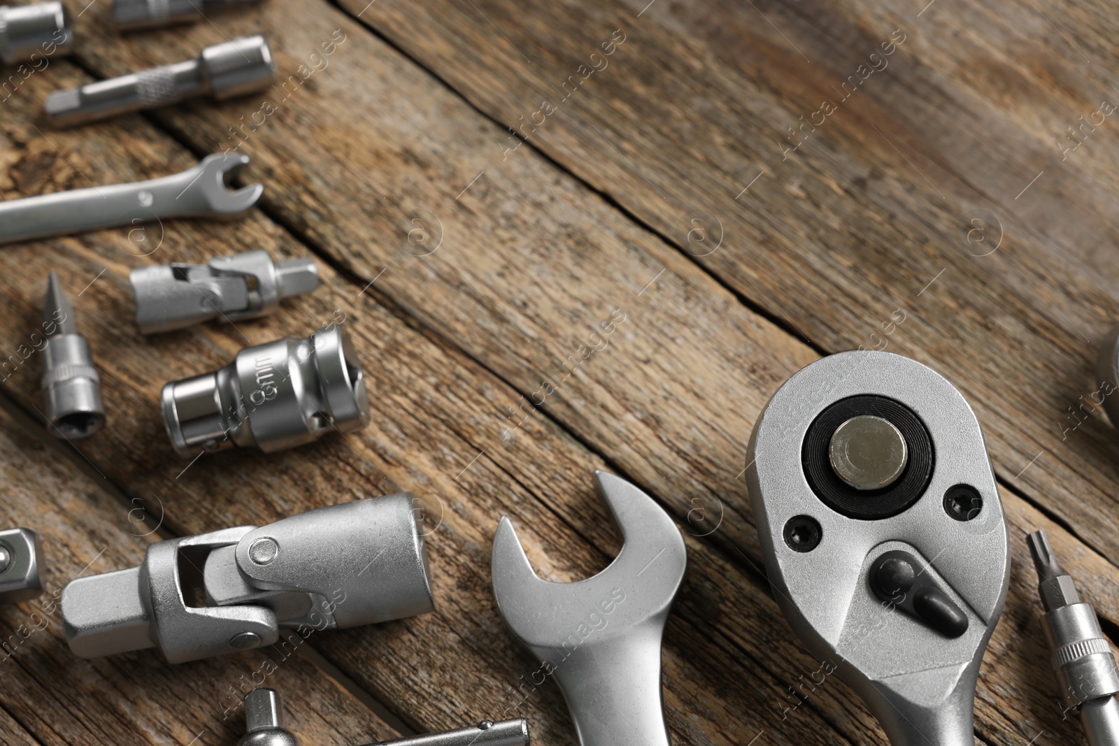 Photo of Different auto mechanic's tools on wooden table, space for text