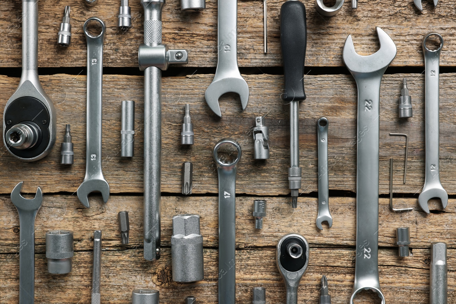 Photo of Different auto mechanic's tools on wooden table, flat lay