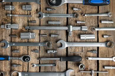 Photo of Different auto mechanic's tools on wooden table, flat lay