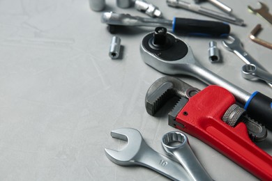 Photo of Different auto mechanic's tools on grey table, space for text