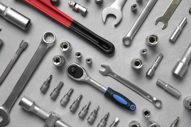 Photo of Different auto mechanic's tools on grey table, flat lay