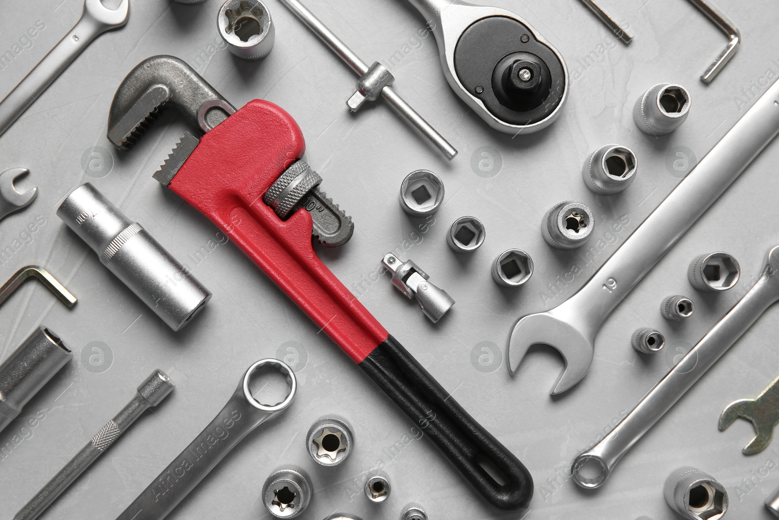 Photo of Different auto mechanic's tools on grey table, flat lay