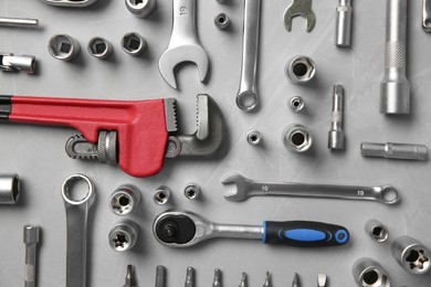 Photo of Different auto mechanic's tools on grey table, flat lay