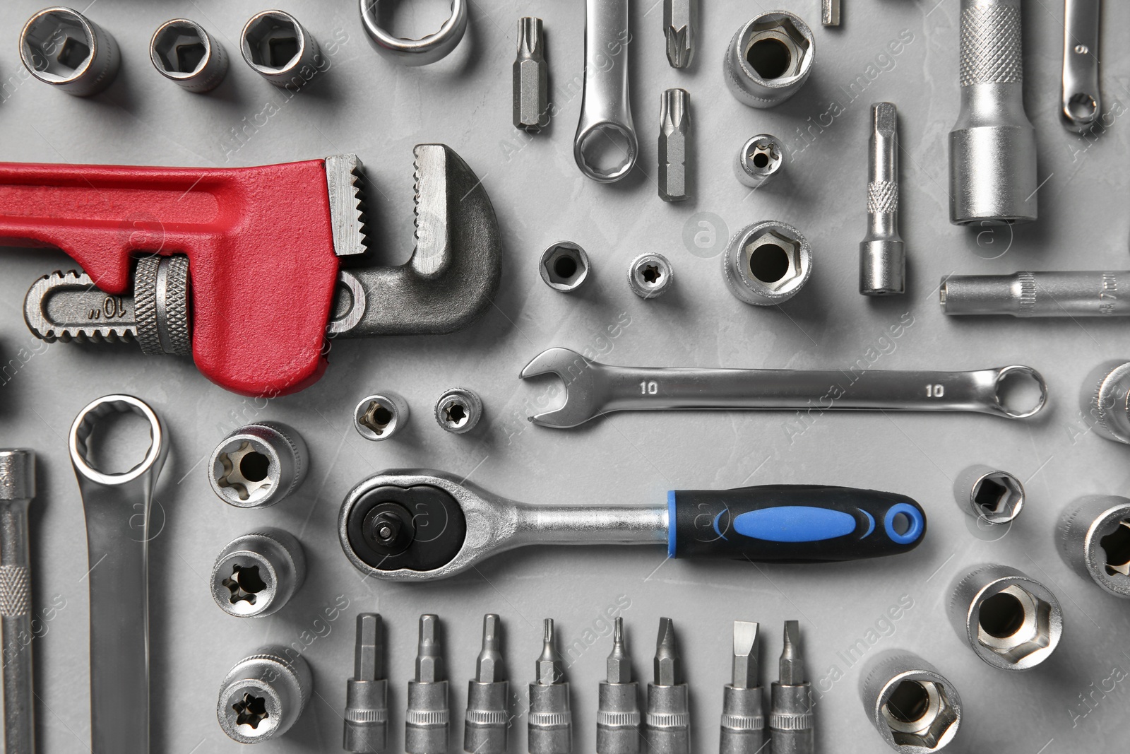 Photo of Different auto mechanic's tools on grey table, flat lay