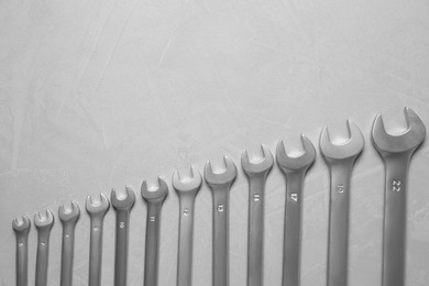 Photo of Auto mechanic's tools on grey table, flat lay. Space for text