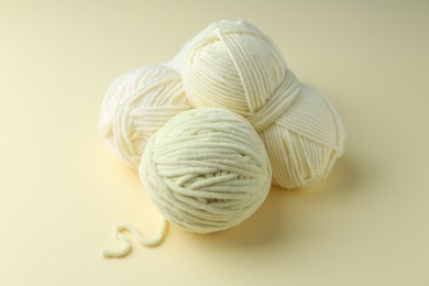 Photo of Three skeins of plush yarn on beige background. Knitting material