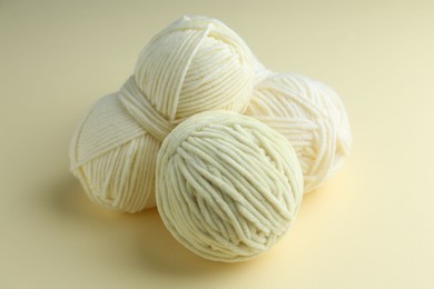 Photo of Three skeins of plush yarn on beige background. Knitting material