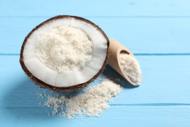 Photo of Fresh coconut flour in nut and scoop on light blue wooden table