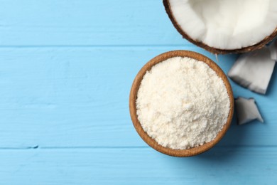 Photo of Fresh coconut flour in bowl and nut on light blue wooden table, top view. Space for text