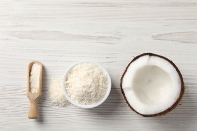 Photo of Fresh coconut flour in bowl, scoop and nut on white wooden table, flat lay