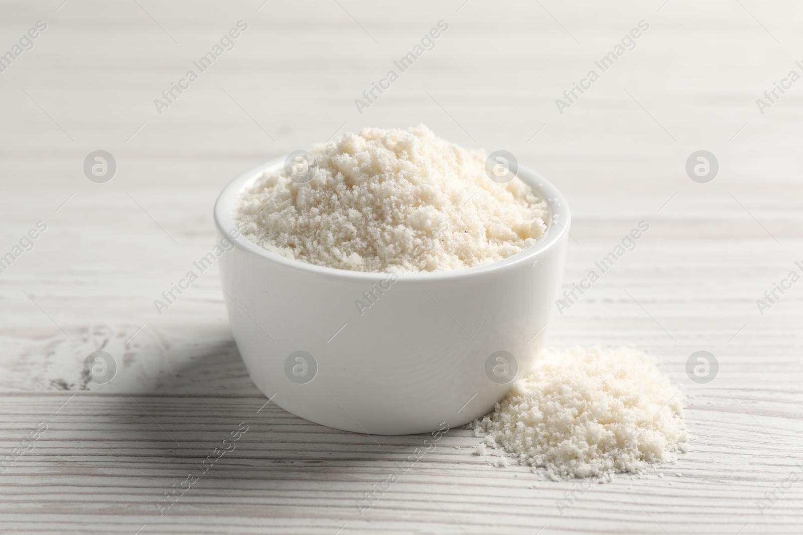 Photo of Fresh coconut flour in bowl on white wooden table